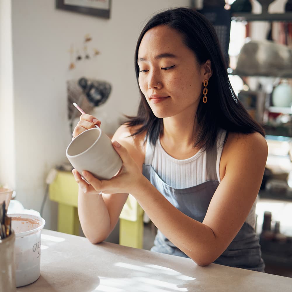 Woman painting pottery